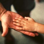 Father and son touching hands